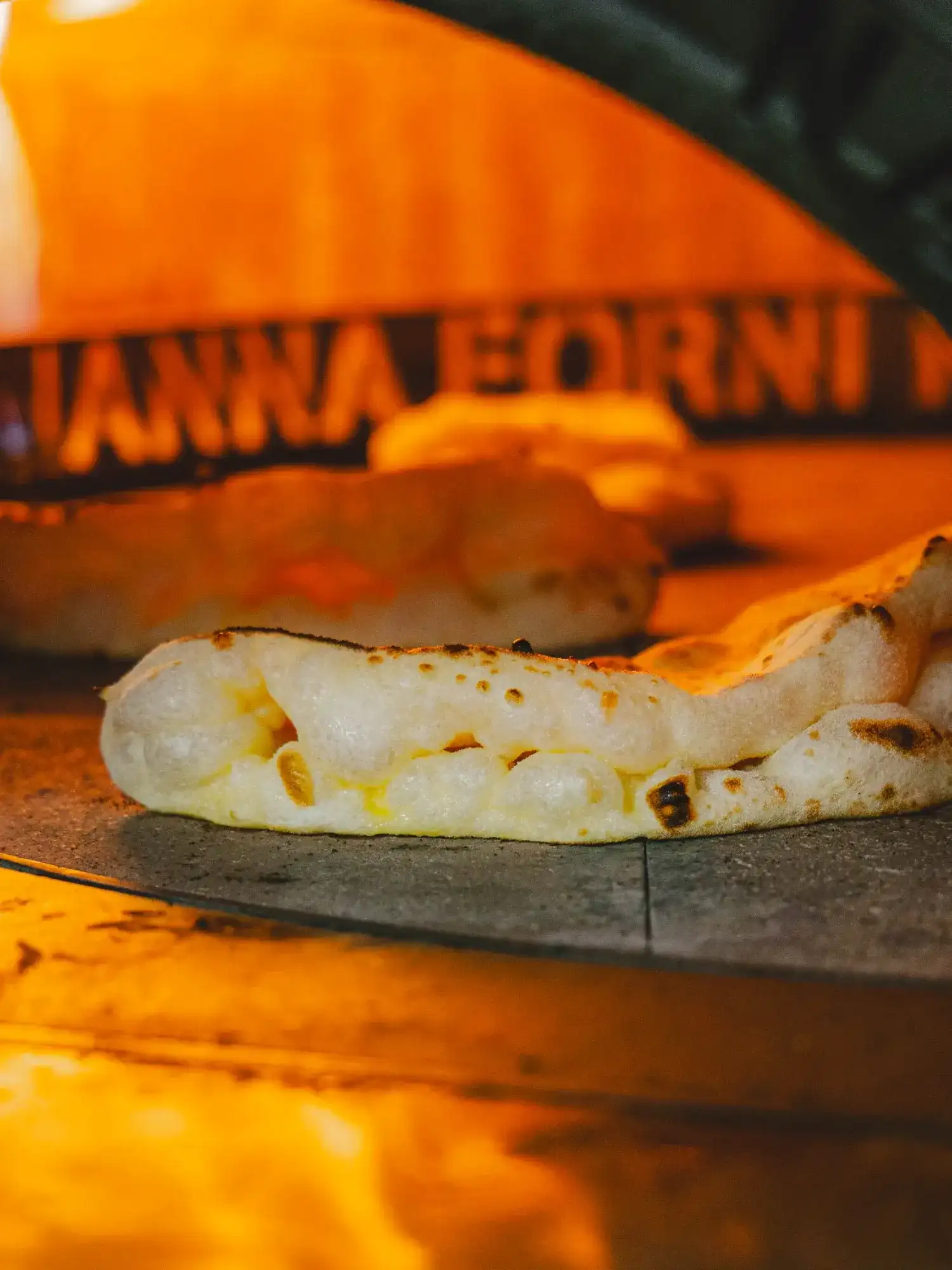 Enfournement d’une pizza dans le four à bois